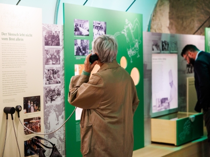 Eine Besucherin der Sonderausstellung La Charmille an einer der Höhrstationen